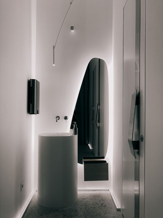 Modern style bathroom interior with sink and mirror near door