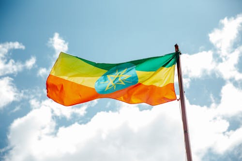 Free National colorful flag of Ethiopia under cloudy sky Stock Photo
