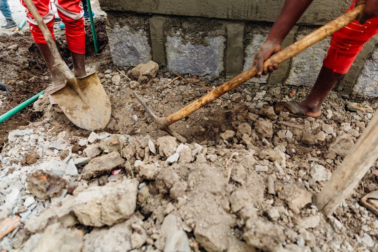 People Digging Using Shovel And Pickaxe