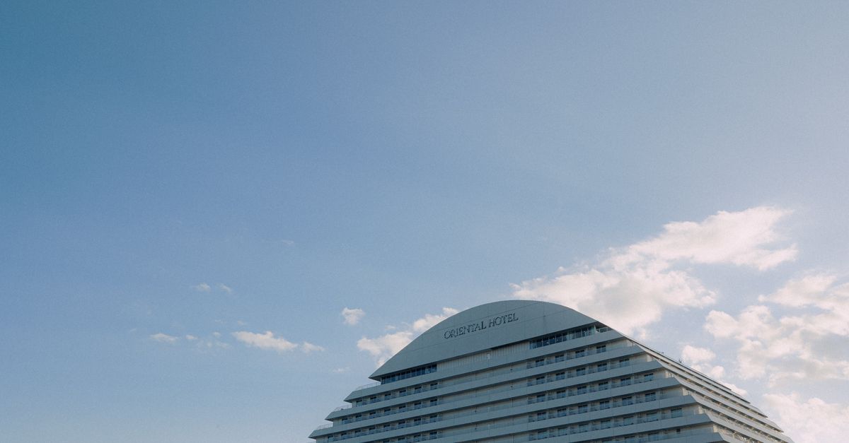 View of the BE KOBE sign with the iconic Meriken Park hotel in Kobe, Japan.