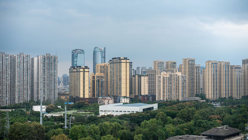 A stunning view of Chengdu's skyline featuring modern skyscrapers and lush greenery under a cloudy sky.