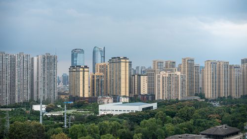 Free A stunning view of Chengdu's skyline featuring modern skyscrapers and lush greenery under a cloudy sky. Stock Photo
