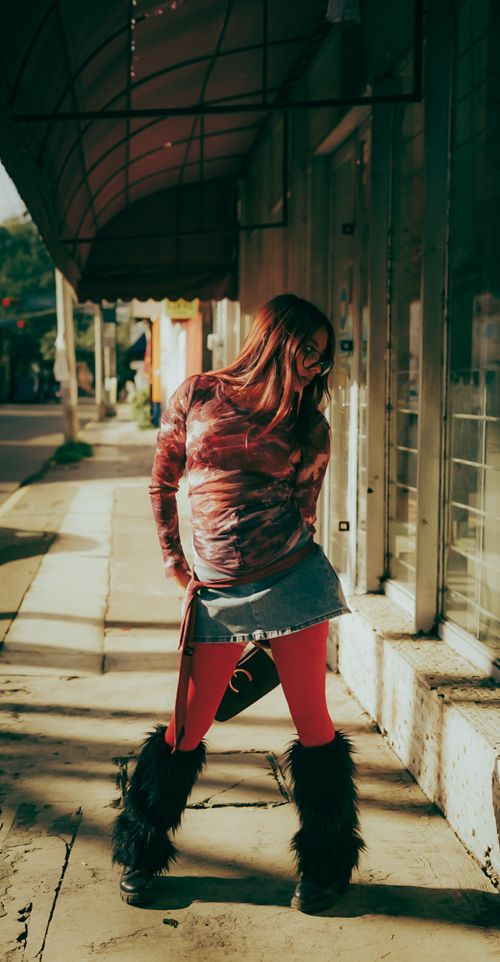 Free Fashionable young adult woman posing stylishly outdoors in urban environment. Stock Photo