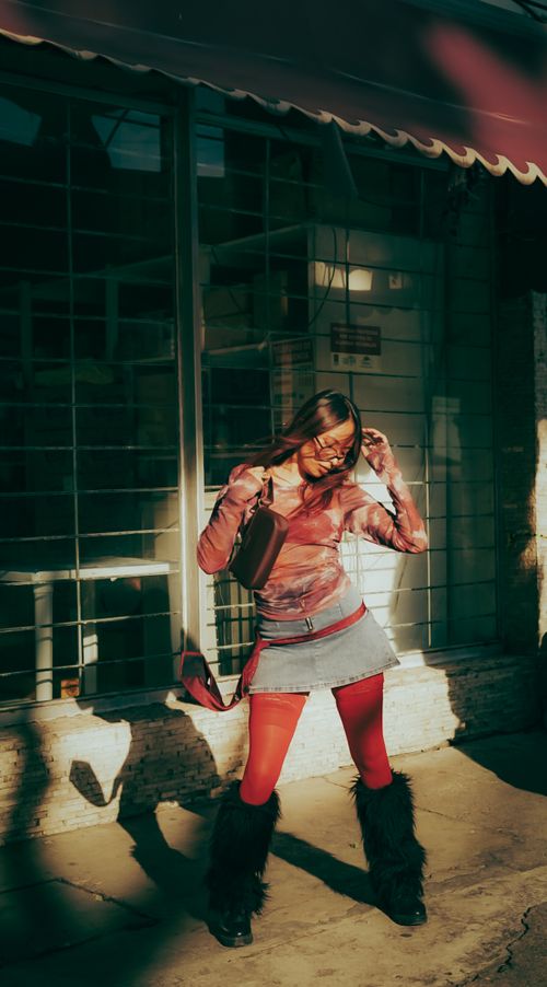 Free Trendy young woman in stylish attire posing outdoors under sunlight. Stock Photo