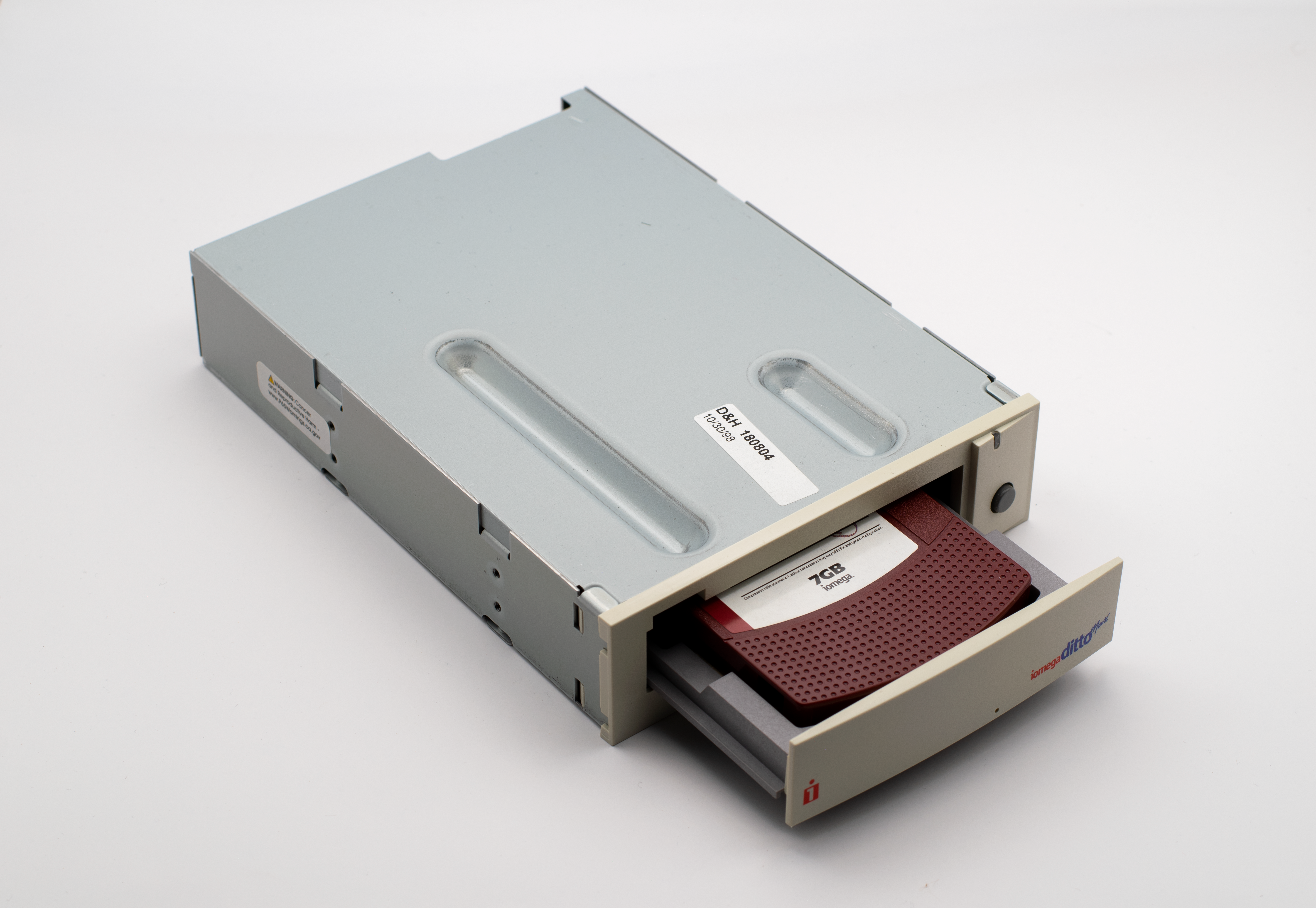 Close-up of a vintage internal tape drive with a storage media cartridge partially ejected.