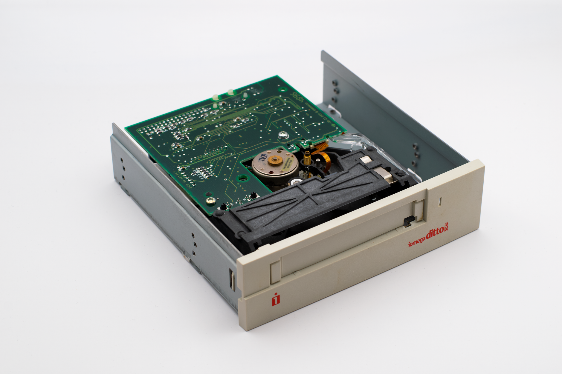 Close-up of a vintage Iomega Ditto internal tape drive with circuit board exposure.