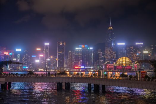 Night view of Kowloon's vibrant cityscape with illuminated skyscrapers and neon lights.