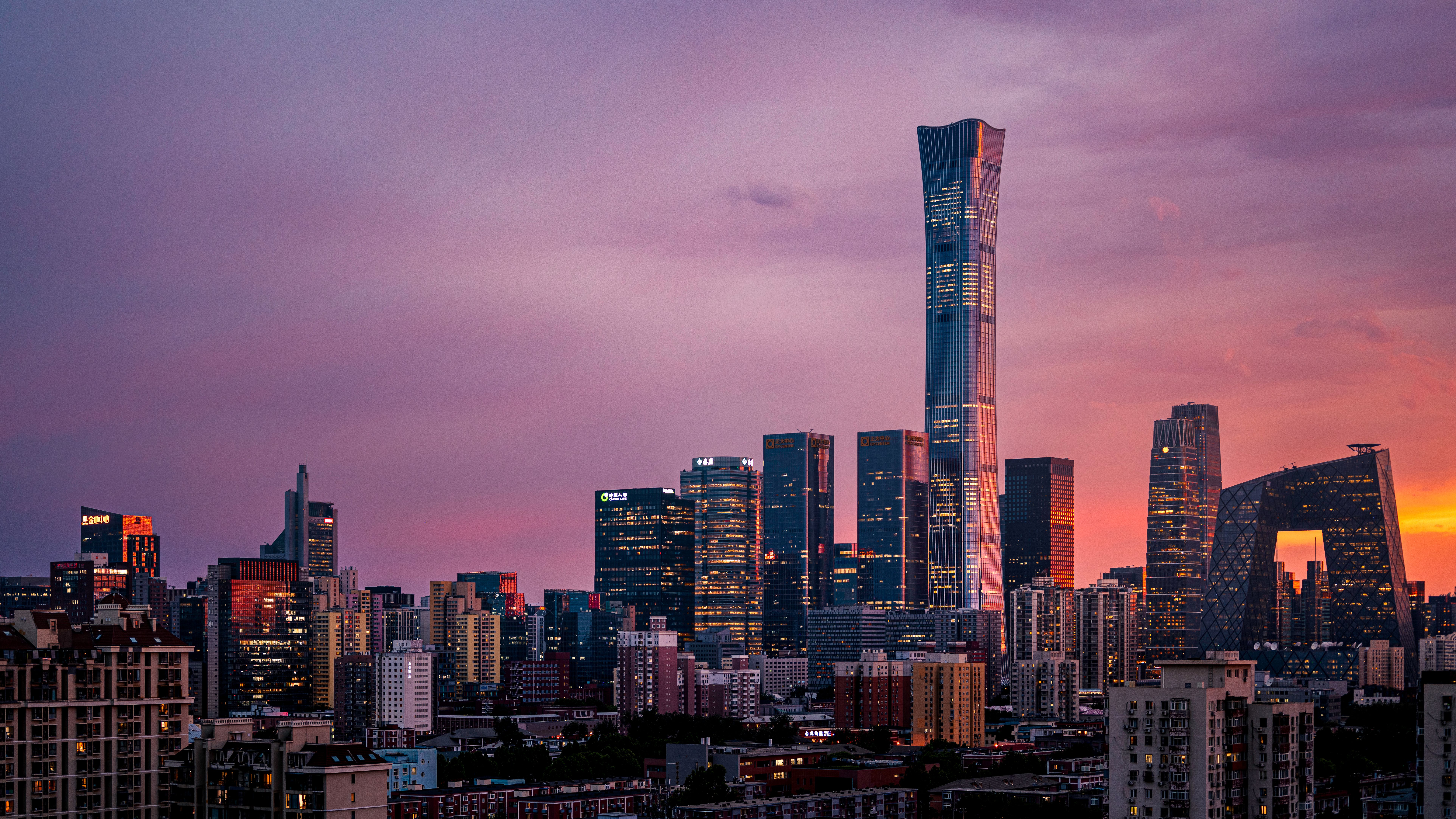 Beijing's skyline at sunset with iconic landmarks silhouetted against a vibrant sky.