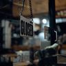 A 'Closed' sign hanging on a dark glass door.