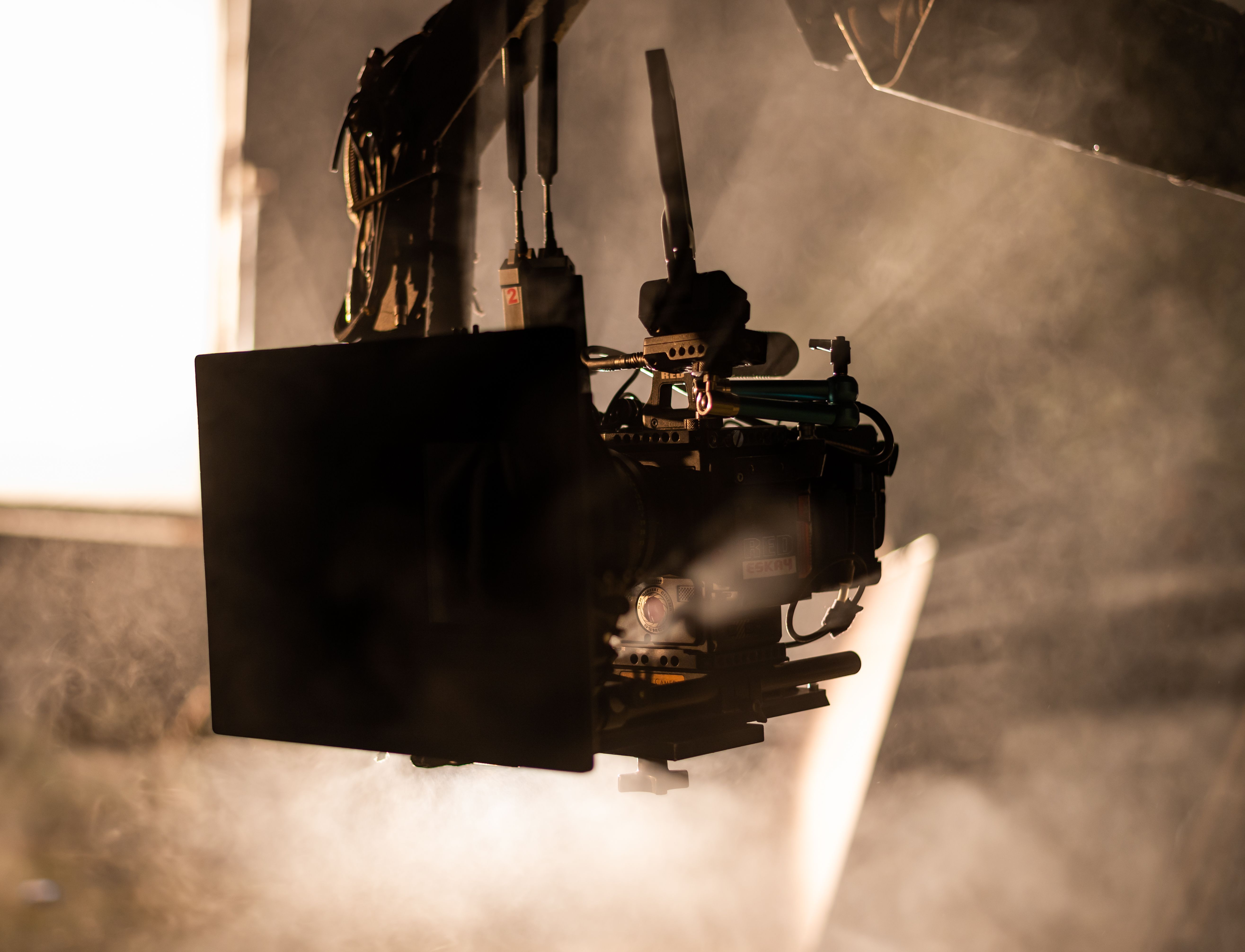 Close-up of a professional film camera in a smoky studio environment, highlighting filmmaking equipment.