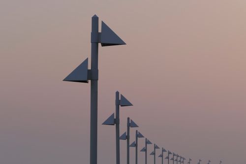 Free A row of modern street lamps align symmetrically under a serene pink sunset in Norderney, Germany. Stock Photo