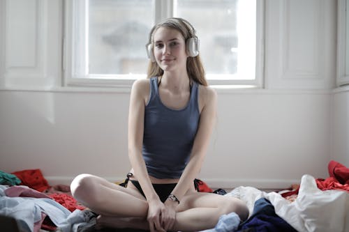 Glad woman listening to music in headphones at home