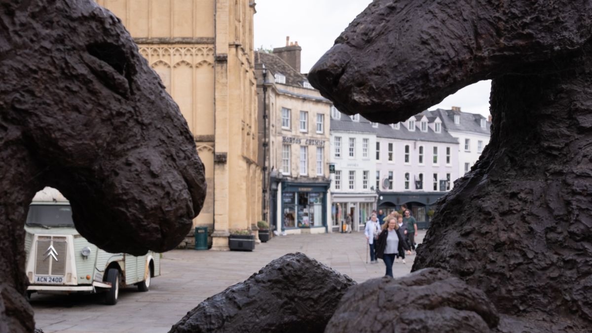 Bronze hare sculptures in Cirencester Market Place with the parish church tower behind