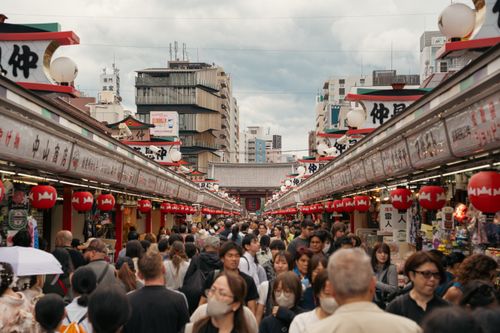 Free Vibrant street market in Asakusa, Tokyo with red lanterns and bustling crowd. Stock Photo