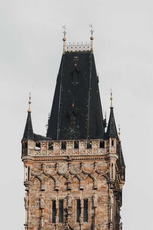 Free Close-up of a historic Gothic tower in Prague, showcasing detailed architecture under a cloudy sky. Stock Photo