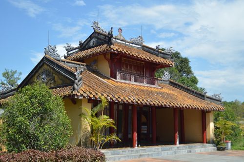 Free A beautiful traditional Vietnamese pagoda with intricate tile roofing and dragon carvings under a clear blue sky. Stock Photo