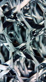 Detailed macro shot of a shiny metallic mesh with interwoven strands showing texture and design.