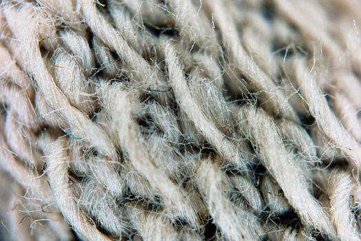 Detailed macro image of intertwined tan wool fibers showcasing texture and intricacy.