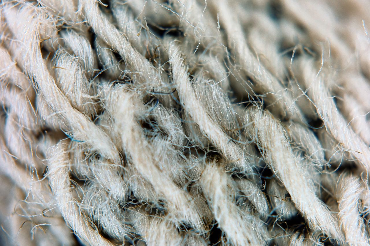 detailed macro image of intertwined tan wool fibers showcasing texture