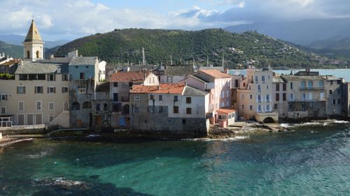 Free Picturesque coastal view of Saint-Florent, Corsica with historical architecture and clear blue sea. Stock Photo