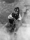 Black and White Photo of Woman with Sledgehammer Sitting on Ground