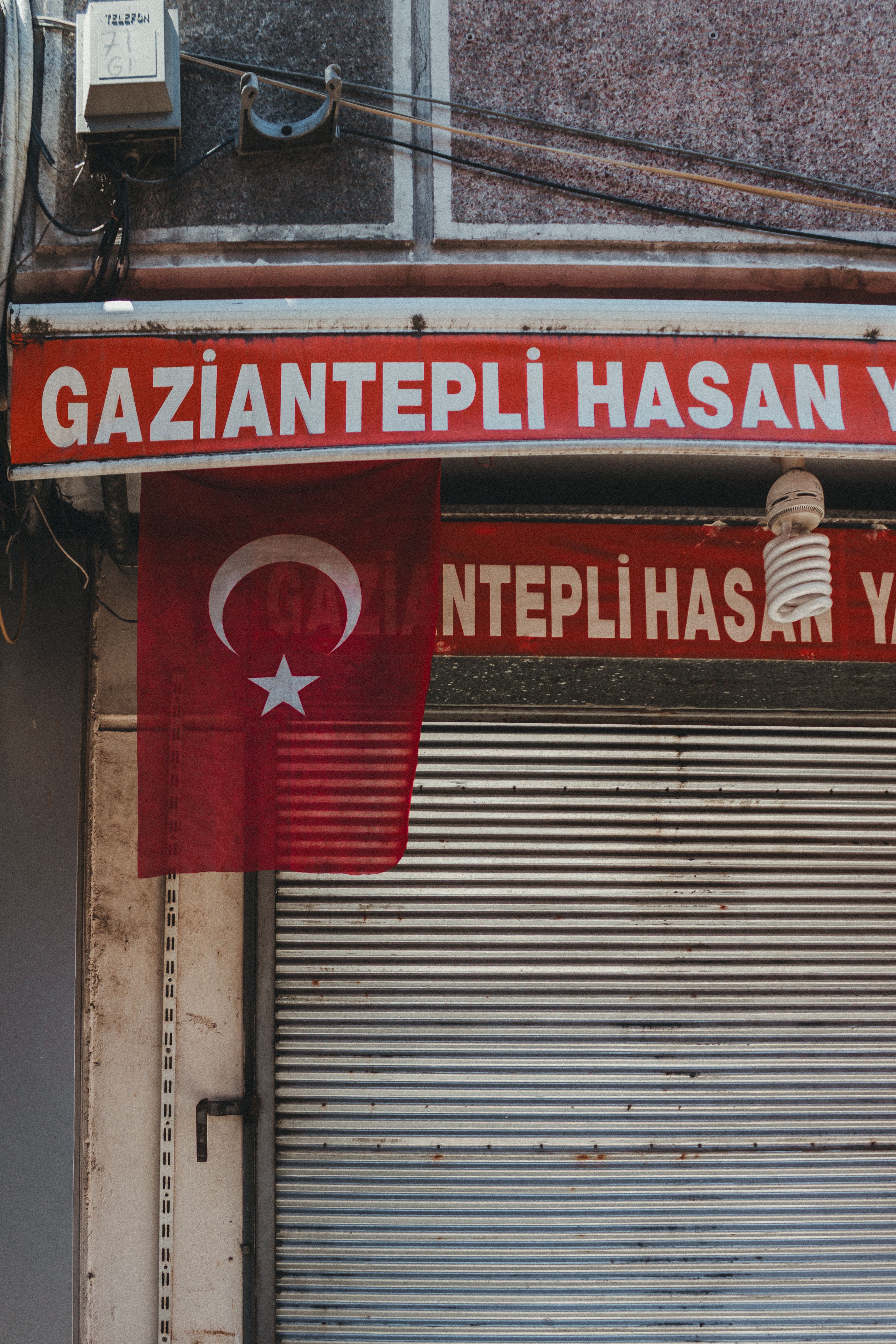 Close-up of a Turkish flag and storefront signage in Istanbul, Turkey.