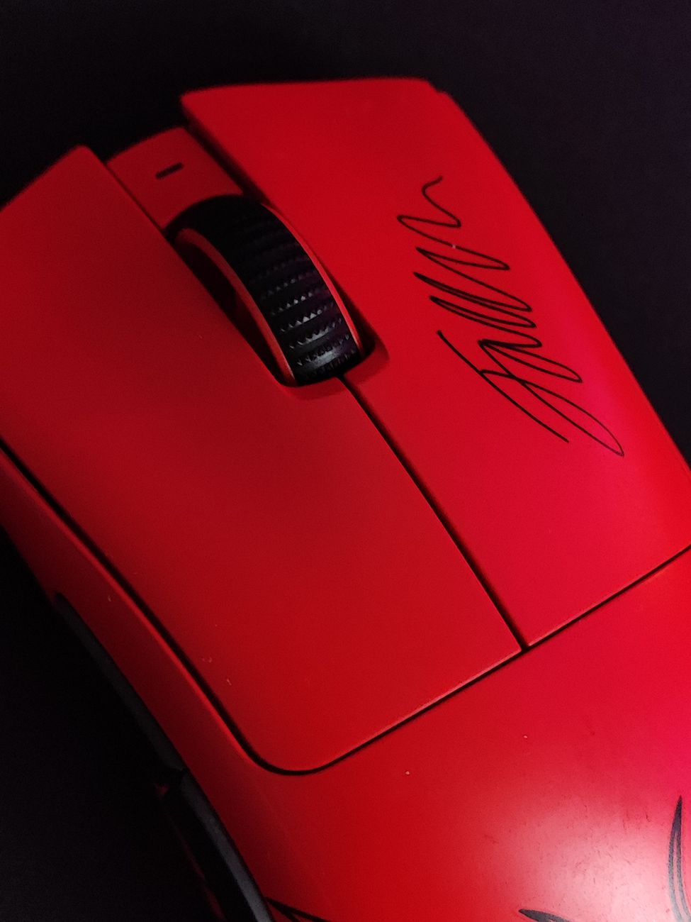 Close-up of a premium red gaming mouse with a signature, perfect for esports enthusiasts.