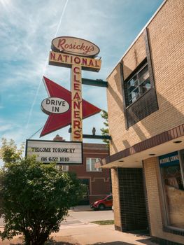 A classic Rosicky's National Cleaners sign outside a brick building under a bright sky.