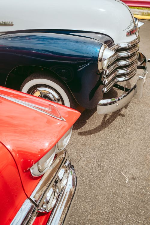 Free Close-up of vintage classic cars with chrome details on display at an outdoor automotive show. Stock Photo