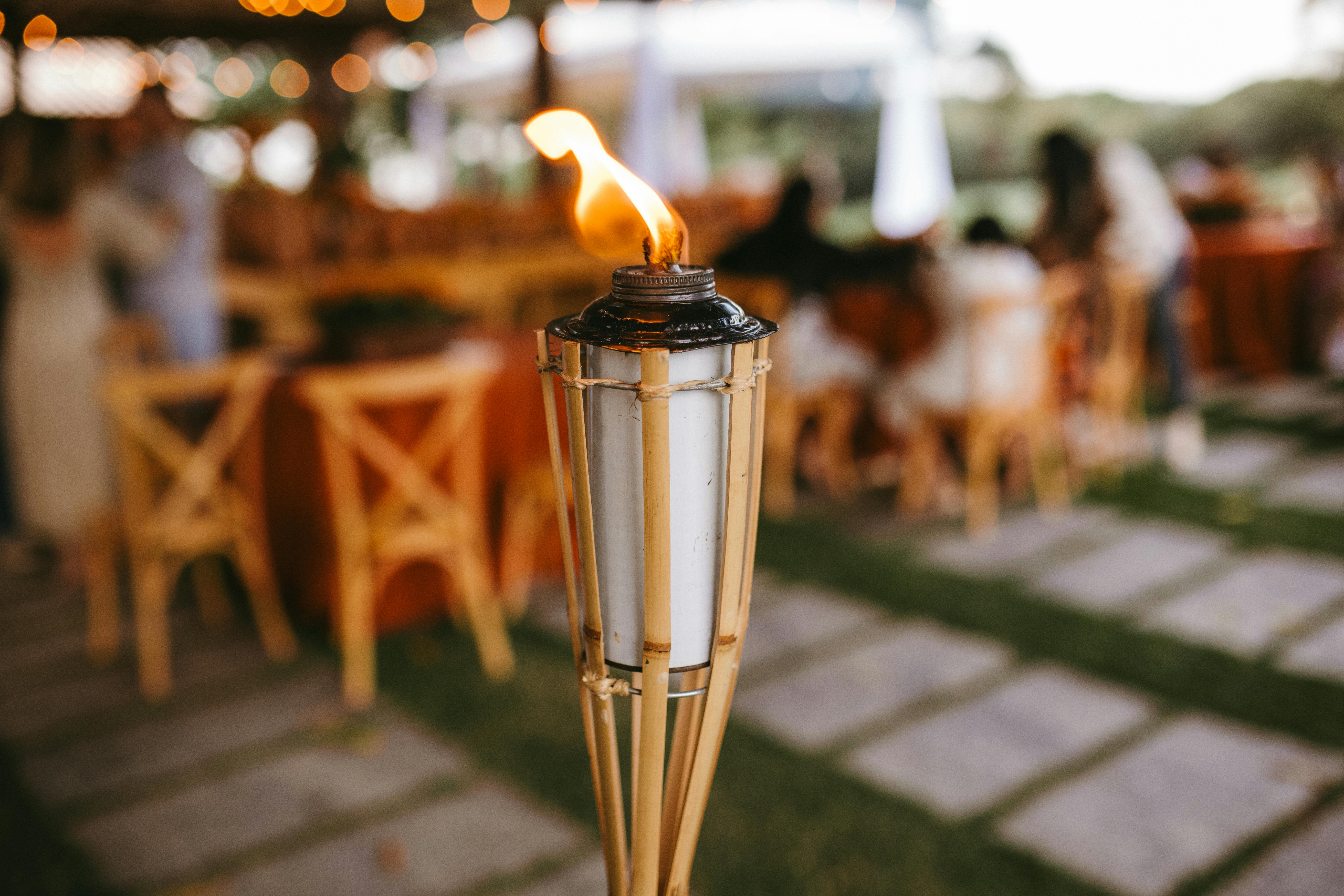 A bamboo torch enhances the ambiance of an elegant outdoor wedding or event.