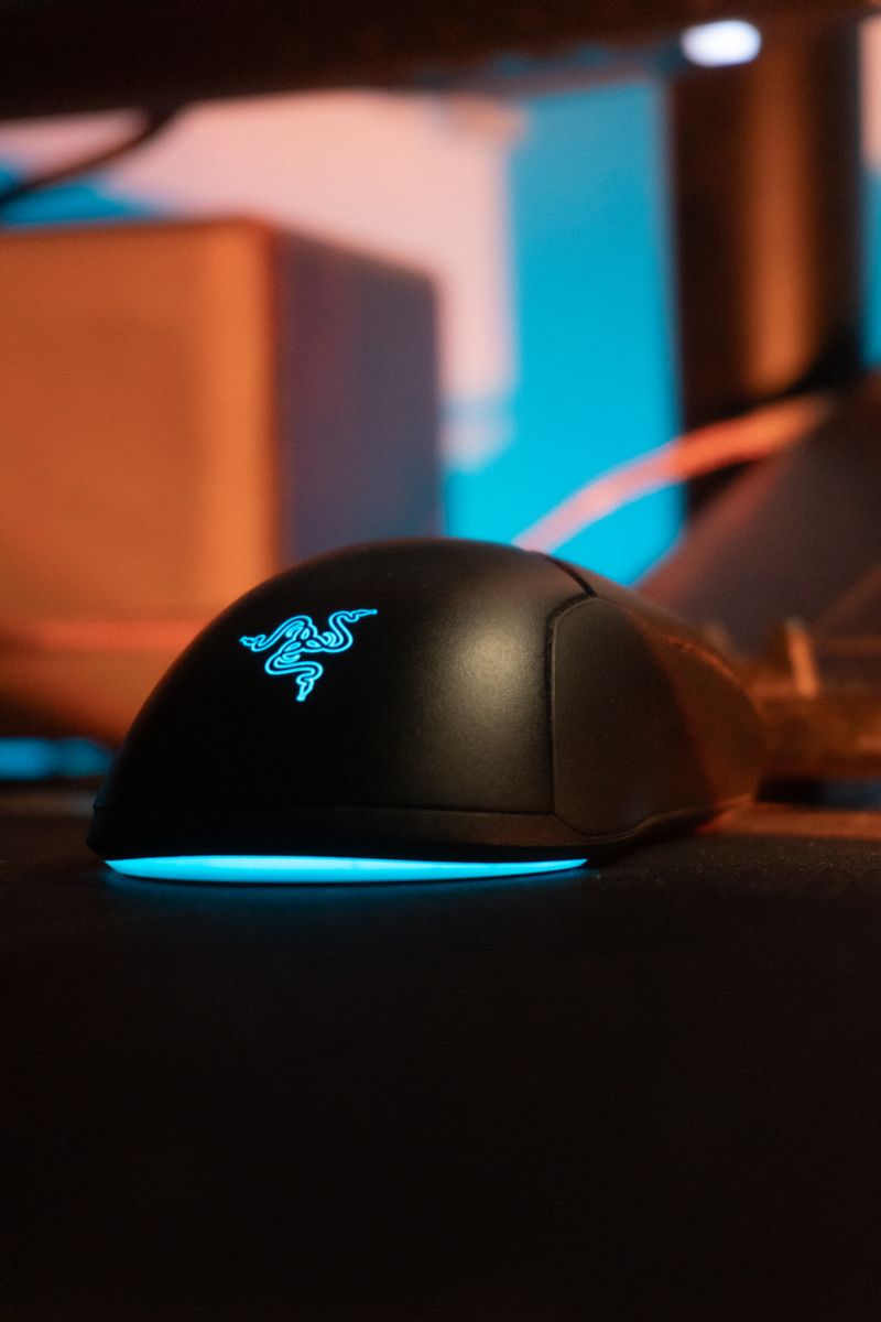 A close-up shot of an illuminated gaming mouse highlighting its sleek design and glowing logo.