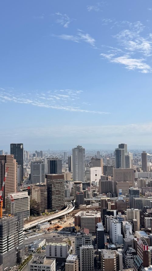 Free Aerial view showcasing the modern skyline of Ōsaka on a clear day. Stock Photo