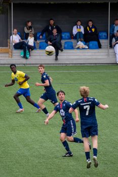 Exciting moment during an amateur soccer match in Vigra, Norway with players and audience engrossed.