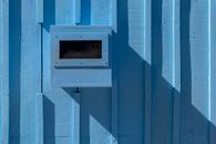 Abstract image of a blue wall with geometric shadows and minimalist design.