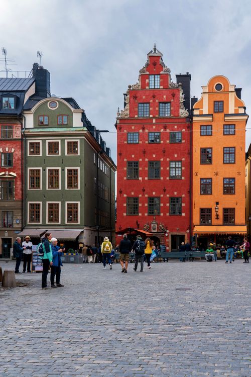 Free Vibrant Gamla Stan buildings in Stockholm with people exploring the historic square. Stock Photo