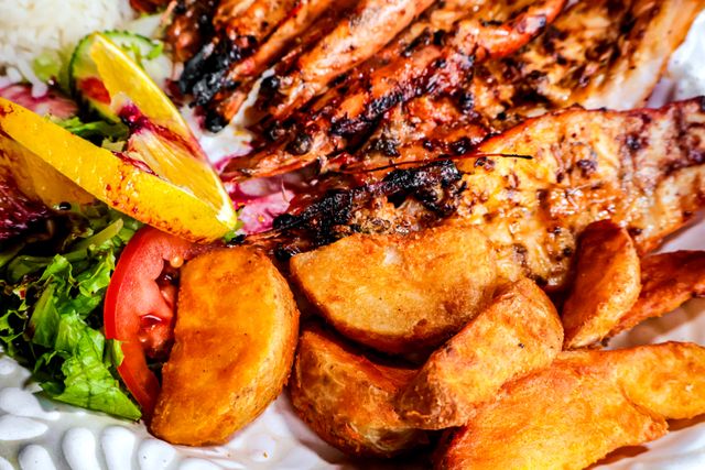 Delicious grilled shrimp with fried potatoes and fresh salad for a perfect meal.