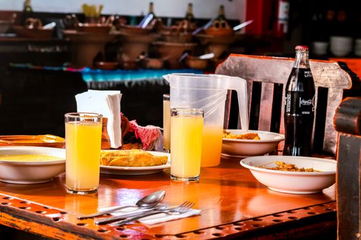 A vibrant spread of traditional Mexican dishes and drinks served on a rustic wooden table.