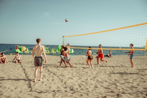 Free Adults enjoying a beach volleyball game under the sun at Lloret de Mar. Stock Photo