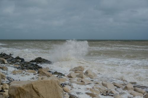Free Powerful waves crash onto a rocky coastline, capturing the raw beauty of nature's force. Stock Photo