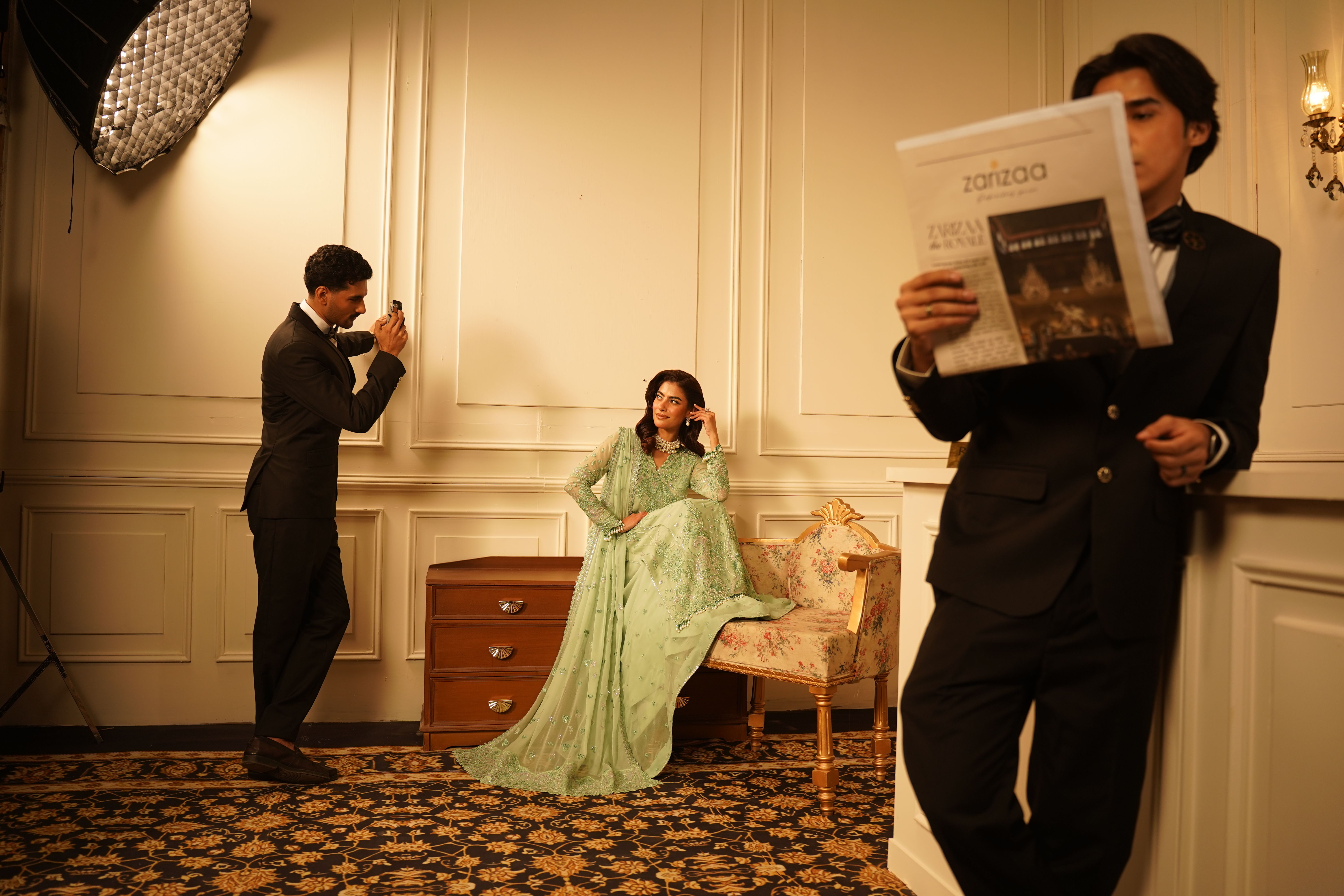Fashion shoot featuring elegantly dressed models in an indoor setting.