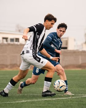 Two soccer players in action on the field, showcasing athletic competition and teamwork.