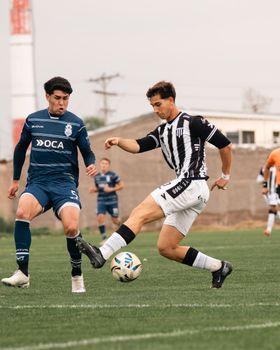 Two soccer players compete fiercely during a match on a lush green field.