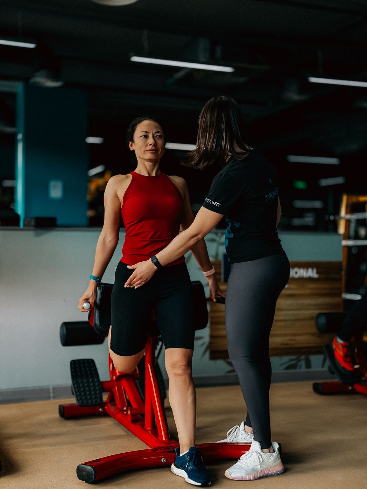 Personal trainer orientando aluno em academia