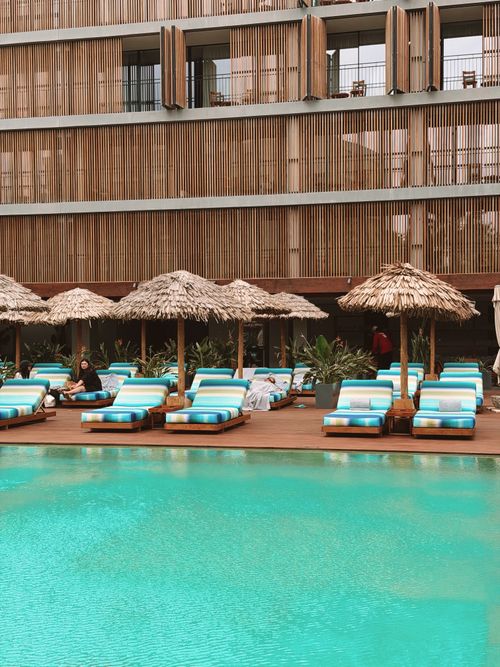 Free Relax by the pool with comfy loungers and tropical vibes at a chic modern resort. Stock Photo