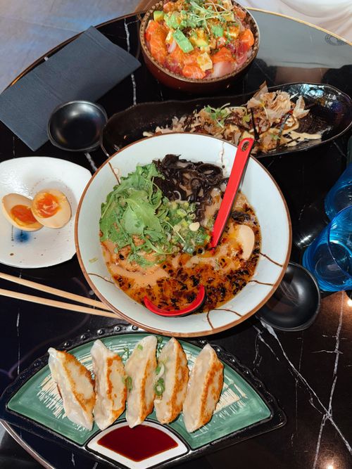 Free Delicious spread of Japanese ramen, gyoza, and sushi served on a modern table. Stock Photo