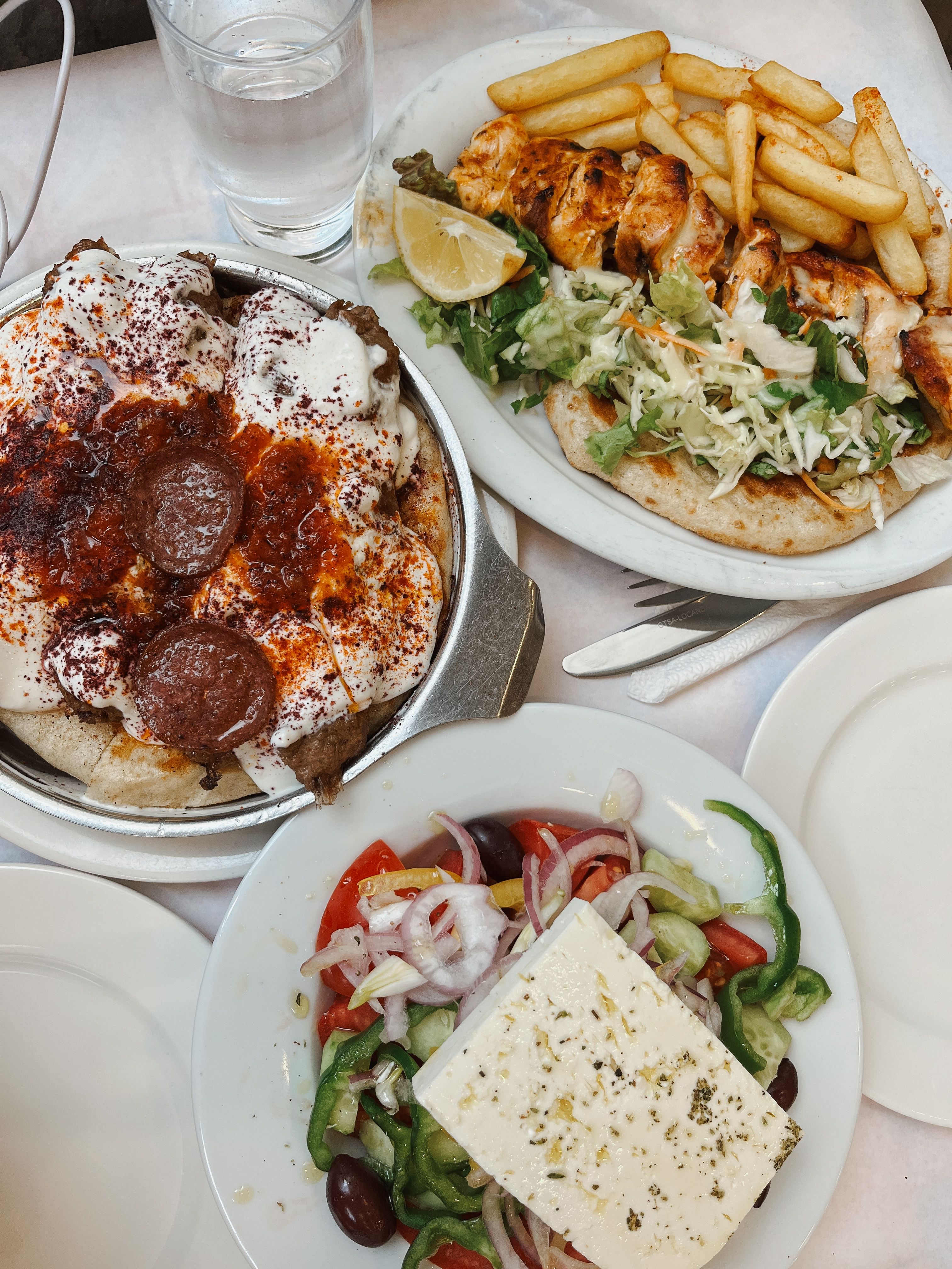 Mouthwatering Greek dishes including souvlaki, pita with meat, and Greek salad featuring feta cheese.