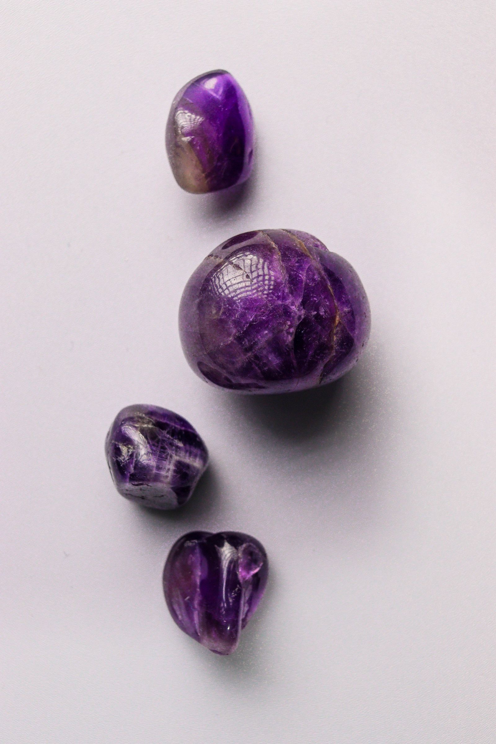 Vibrant purple polished amethyst stones arranged on a light background