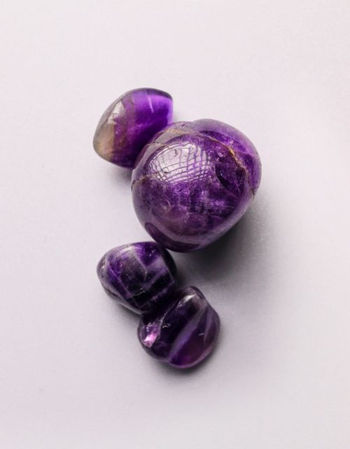 Free Close-up of polished amethyst gemstones showcasing their deep purple hues and smooth textures. Stock Photo