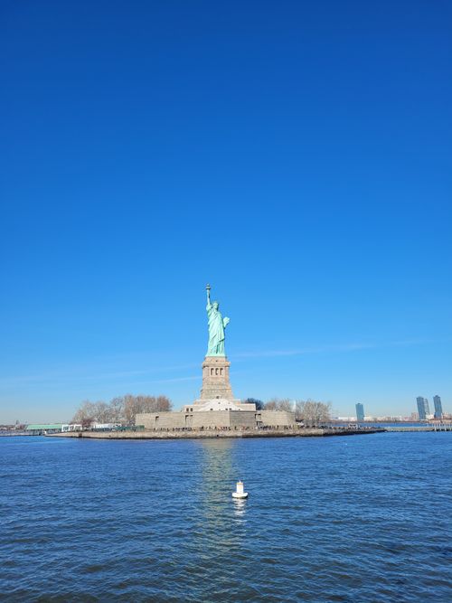 Free The Statue of Liberty with a clear blue sky in New York City, symbolizing freedom and hope. Stock Photo