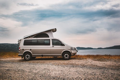 Free White Van on Brown Field Under White Clouds Stock Photo